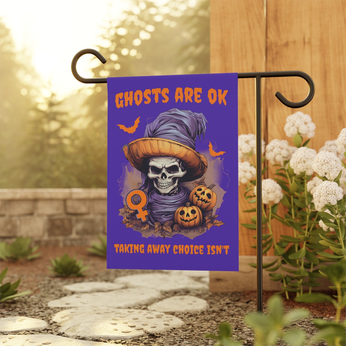 spooky Halloween lawn and garden flag, featuring an eerie skeleton, bats, jack-o-lanterns and the female symbol mixed with a strong pro-choice message, all over a perfect purple background. 