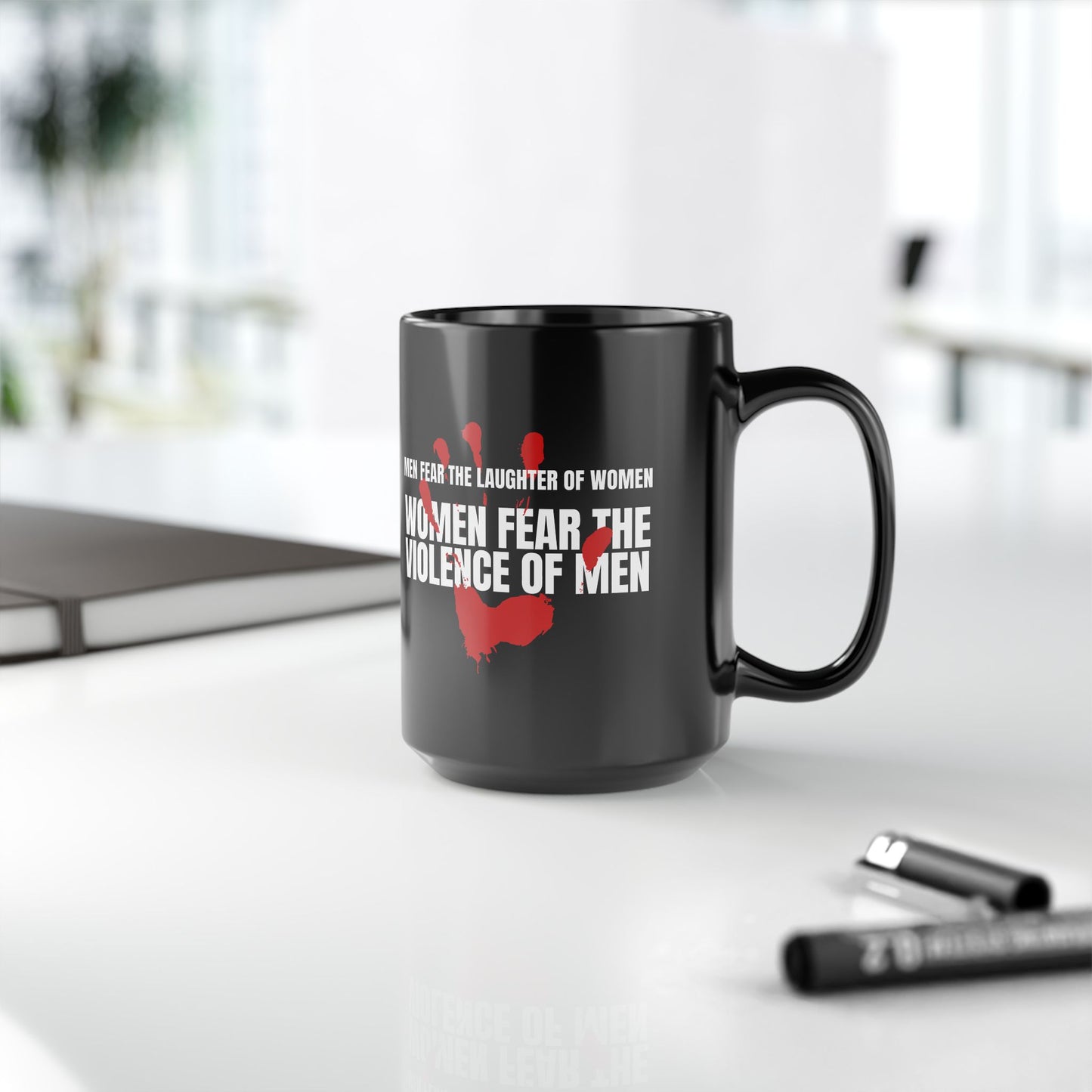 Black coffee mug 15 ounces, with a red handprint and the strongly anti-violence message: Men Fear the Laughter of Women. Women Fear the Violence of Men.  Ideal gift for survivors of domestic violence, support groups, therapists and counselors. 