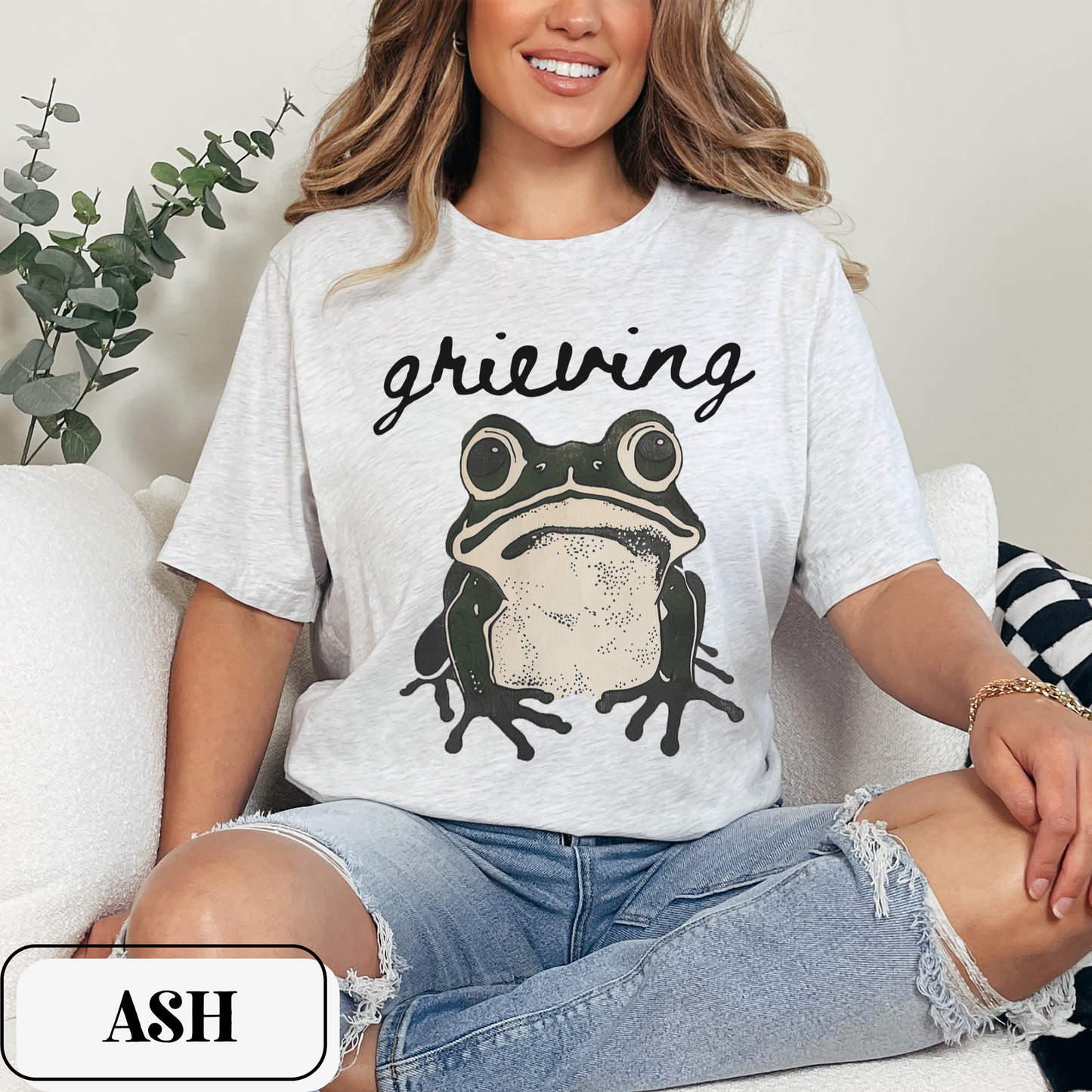 Ash Bella Canvas 3001 T-shirt with a large frog graphic that says "Grieving". A way for people struggling with loss to convey their sorrow - makes a perfect gift for a friend or loved one struggling with grief.