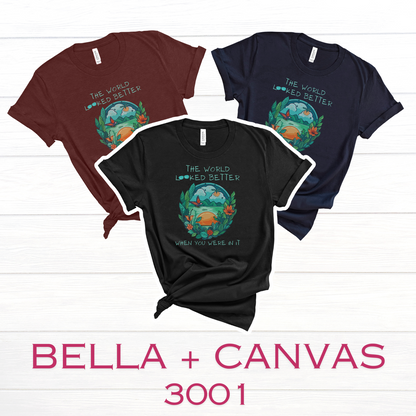Bella Canvas 3001 T-shirt available in Heather Cardinal, Navy and Black. Features a nature scene in blues and greens, and the slogan "The World Looked Better When You Were In It."