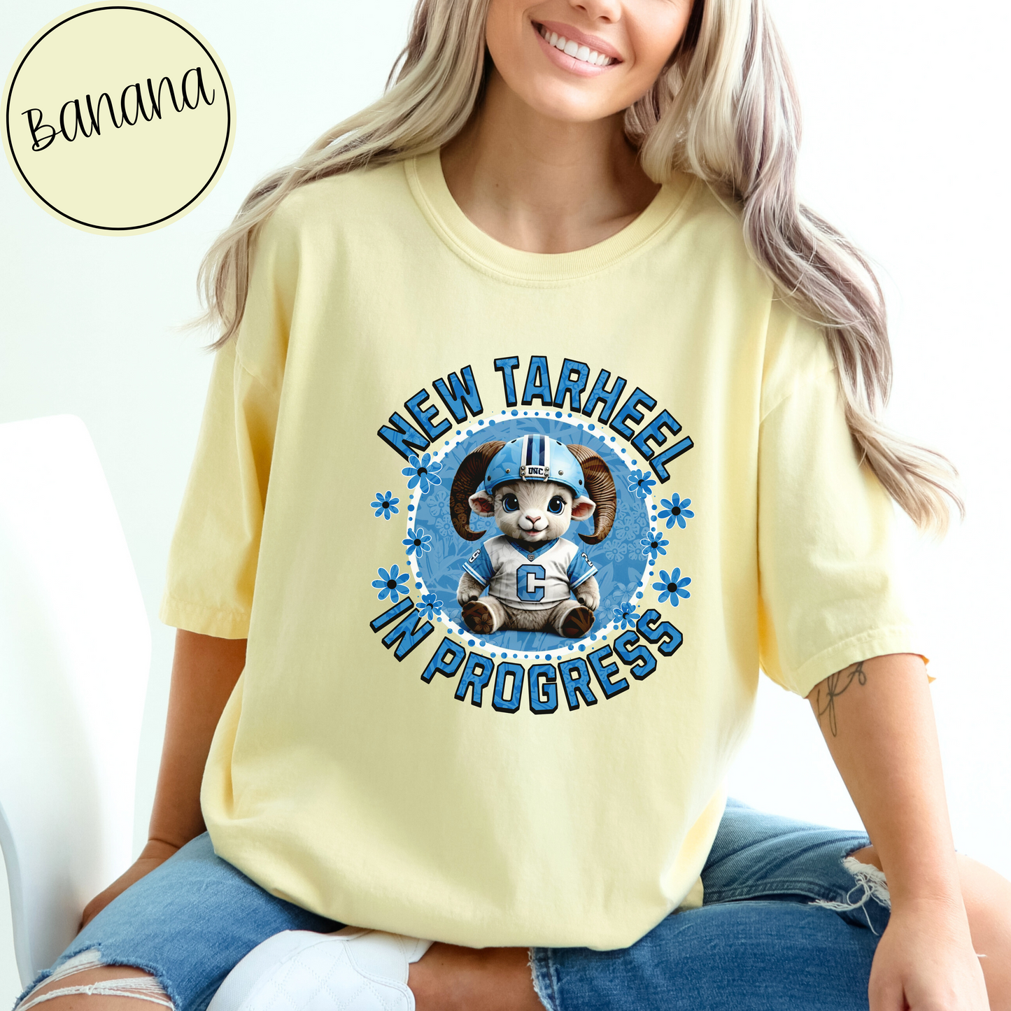 Banana Comfort Colors t-shirt for tarheel fans and mother-to-be. These oversized tees are perfect for early maternity life, and show your love for Carolina sports. It features an adorable baby ram in a football helmet and jersey with the words New Tarheel In Progress.