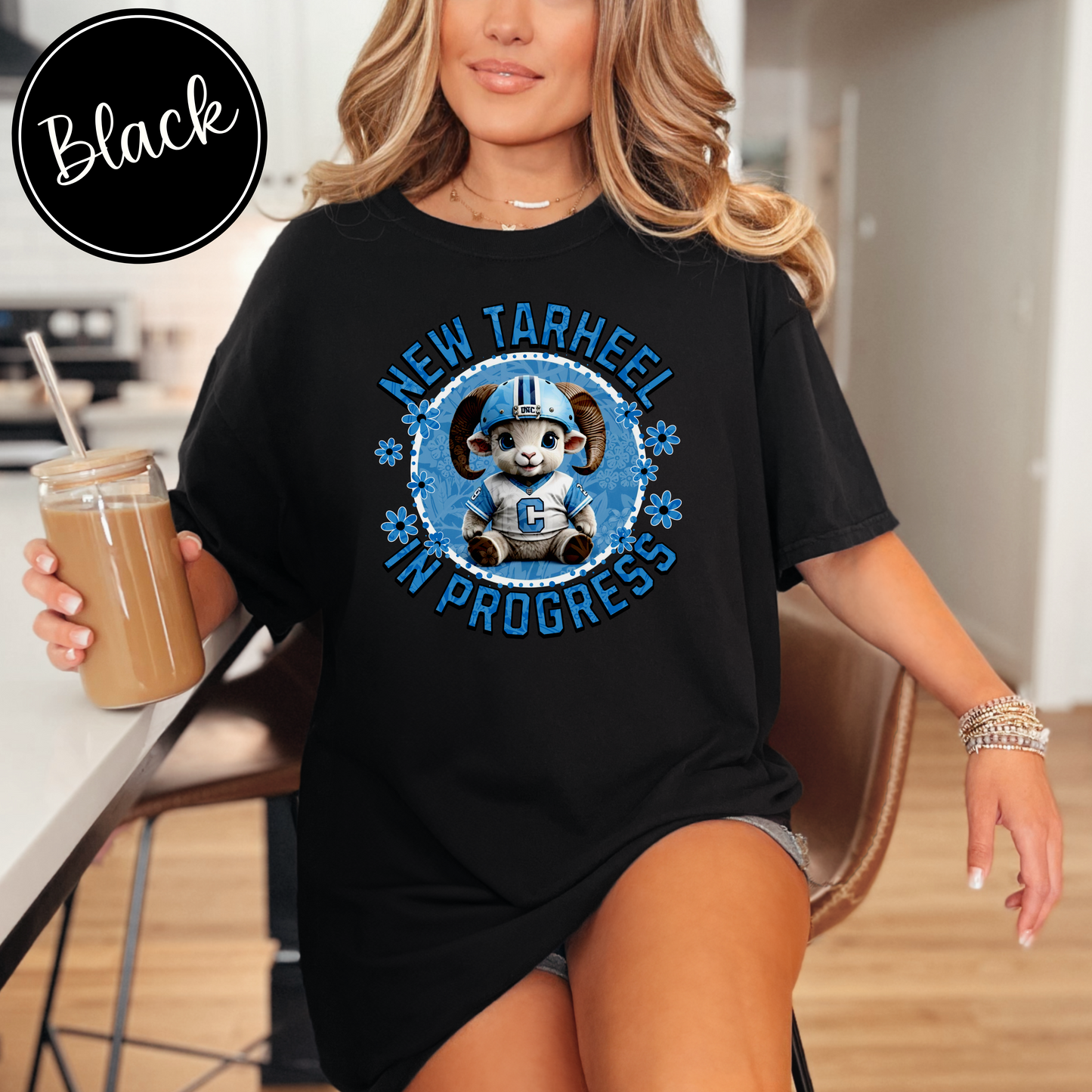 Black Comfort Colors t-shirt for tarheel fans and mother-to-be. These oversized tees are perfect for early maternity life, and show your love for Carolina sports. It features an adorable baby ram in a football helmet and jersey with the words New Tarheel In Progress.