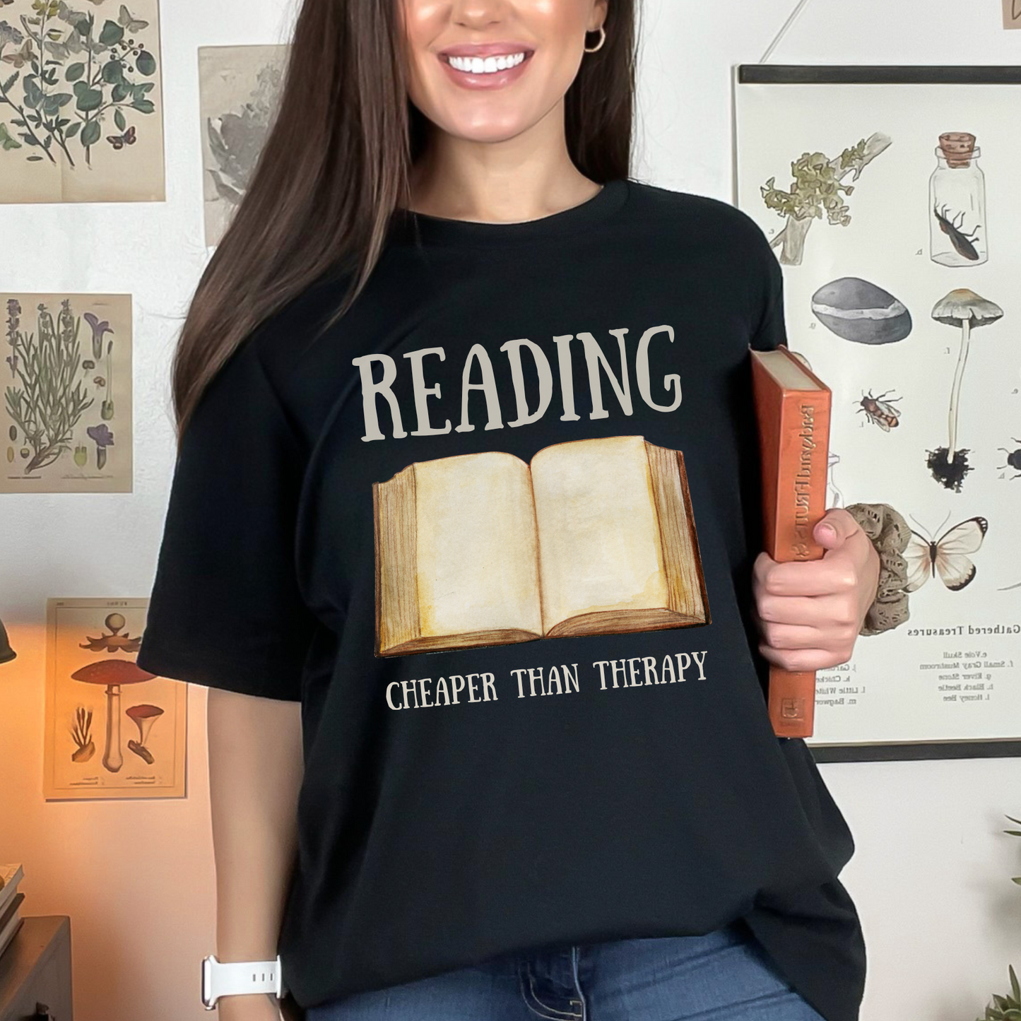 Black Bella Canvas 3001 T-Shirt that says "Reading Cheaper Than Therapy" with a large old fashioned book graphic. Perfect gift for literary enthusiasts, bookish girlfriends, reading or English teachers, and reading lovers.