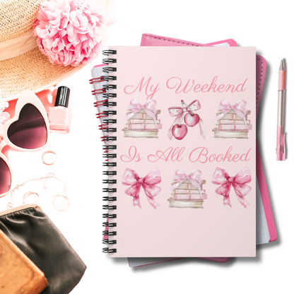 "My Weekend Is All Booked" coquette style spiral notebook. Has blank, lined pages and is a perfect gift for book lovers, bibliophiles, and librarians. Take school notes, make TBR lists, and so much more.