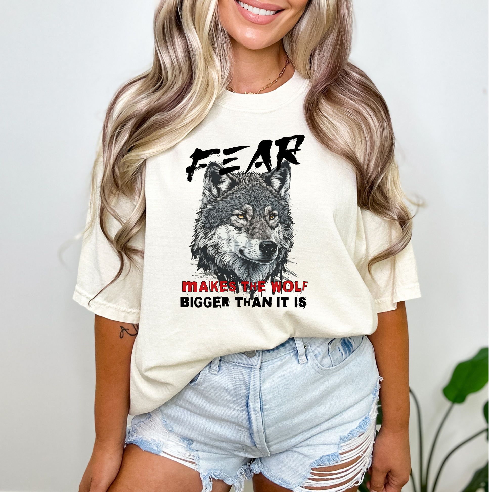 Ivory Comfort Colors t-shirt with a wolf graphic and the phrase: Fear Makes The Wolf Bigger Than It Is. Ideal gift for anyone struggling with fearful challenges to motivate and inspire. 