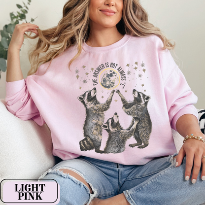 Light Pink Gildan 18000 Sweatshirt with large raccoon and moon/stars graphic that says "The Answer Is Not Always 'C'" - funny meme crewneck for teachers. Great gift for education grad or major, new teacher, educators, etc. Weird teachers goblincore.