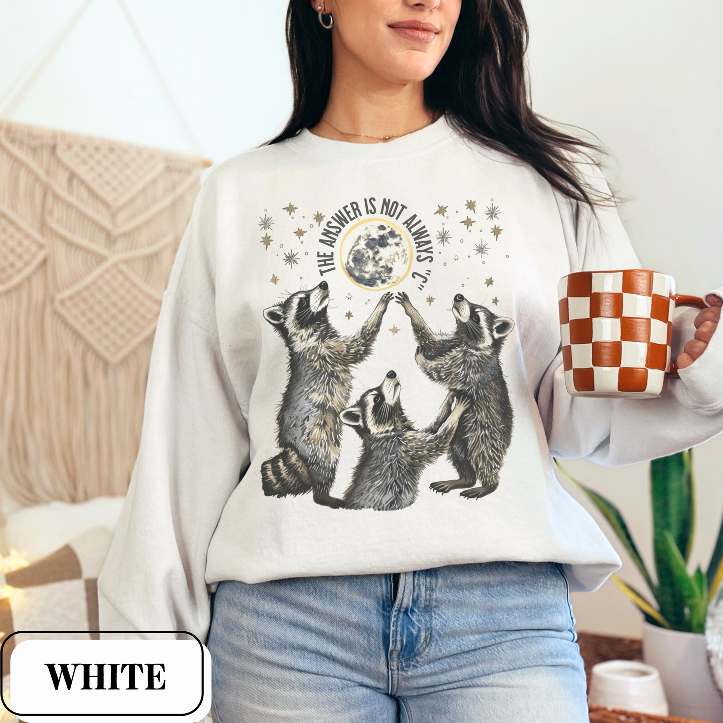 White Gildan 18000 Sweatshirt with large raccoon and moon/stars graphic that says "The Answer Is Not Always 'C'" - funny meme crewneck for teachers. Great gift for education grad or major, new teacher, educators, etc. Weird teachers goblincore.