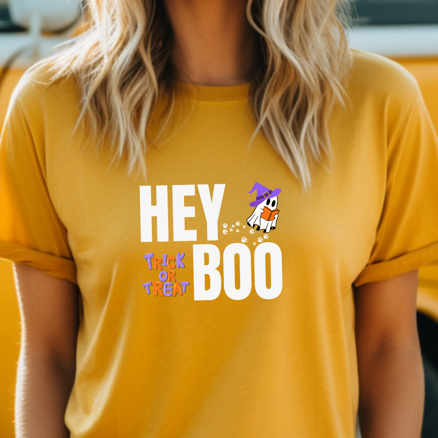 Mustard Hey Boo Halloween t-shirt with an adorable ghost reading with a witches hat on, and paw prints leading up to it. Trick or Treat.