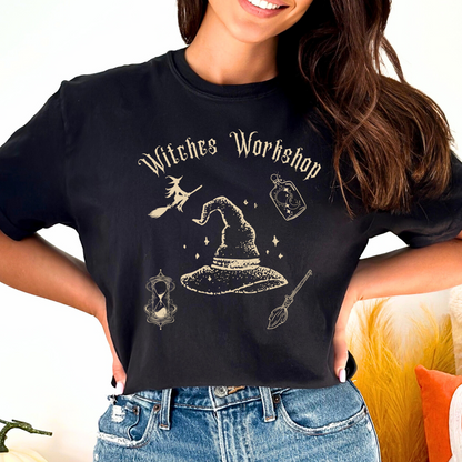 Black Comfort Colors Halloween t-shirt, featuring witches workshop items: enchanted broom, potions bottle, magical hourglass and witches mystical hat