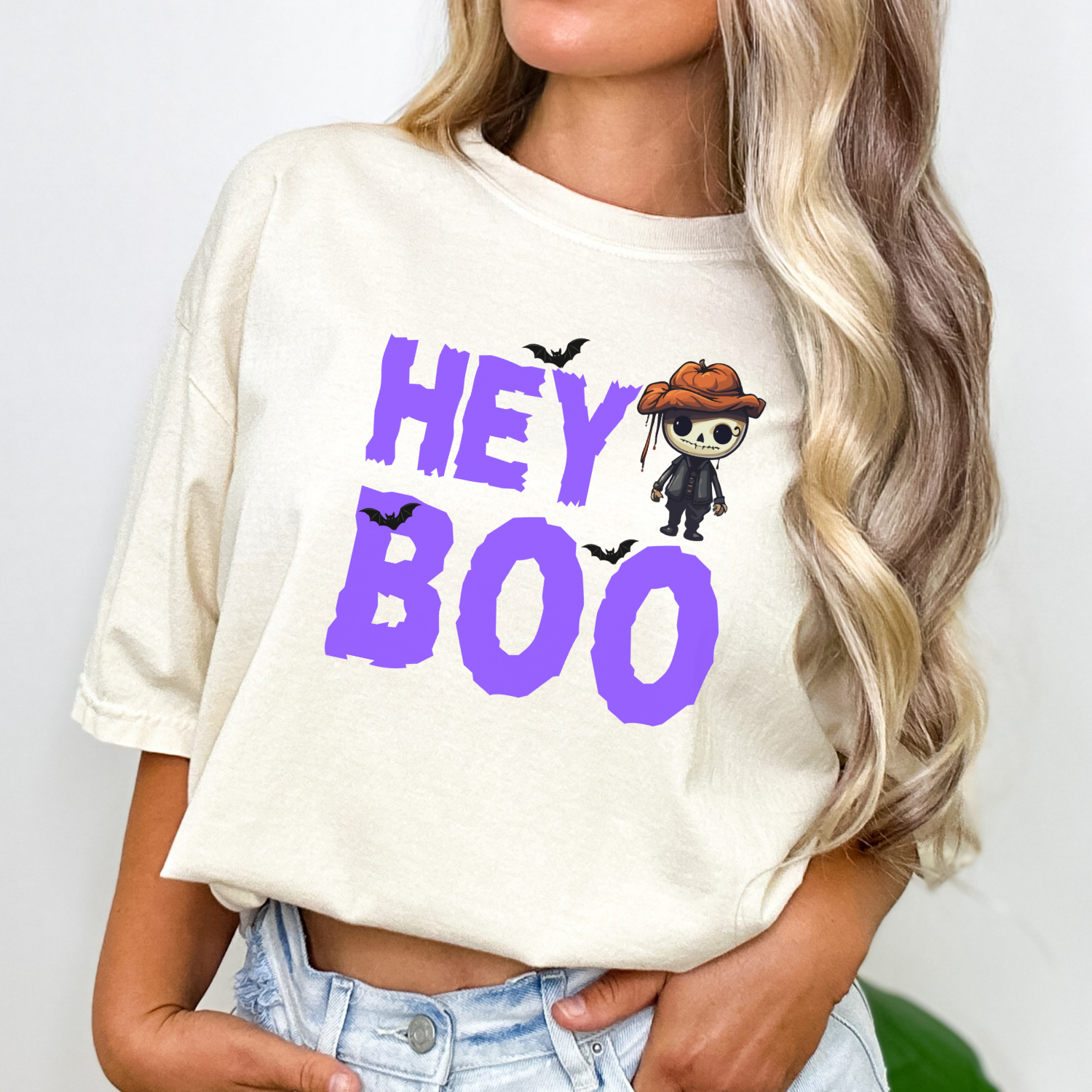 Ivory Comfort Colors Halloween t-shirt from our Hey Boo Collection, featuring a cute pumpkin-head skeleton and bats graphic.