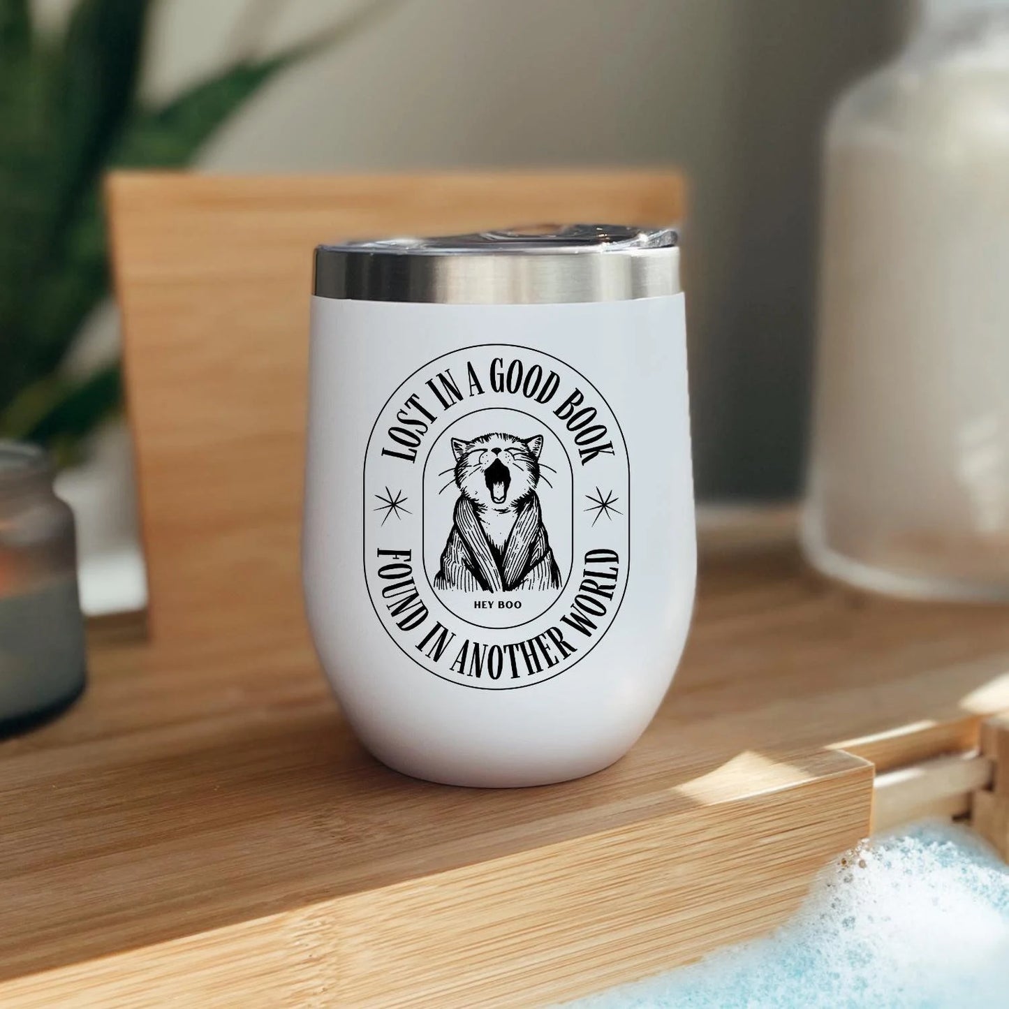 For those who find their happy place between pages, this tumbler is your perfect companion. White wine tumbler with a cat that says &quot;lost in a good book, found in another world&quot;