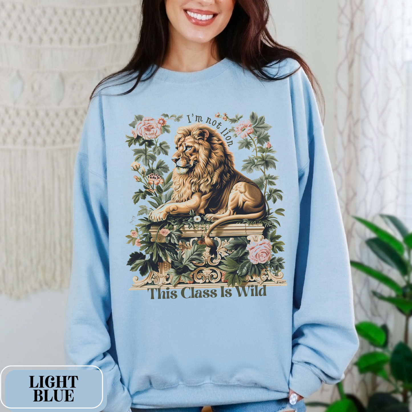 Light Blue Gildan 18000 Sweatshirt with a large Lion graphic with beautiful flowers that says "I'm Not Lion, This Class Is Wild" - perfect gift for teachers, educators, and education majors.