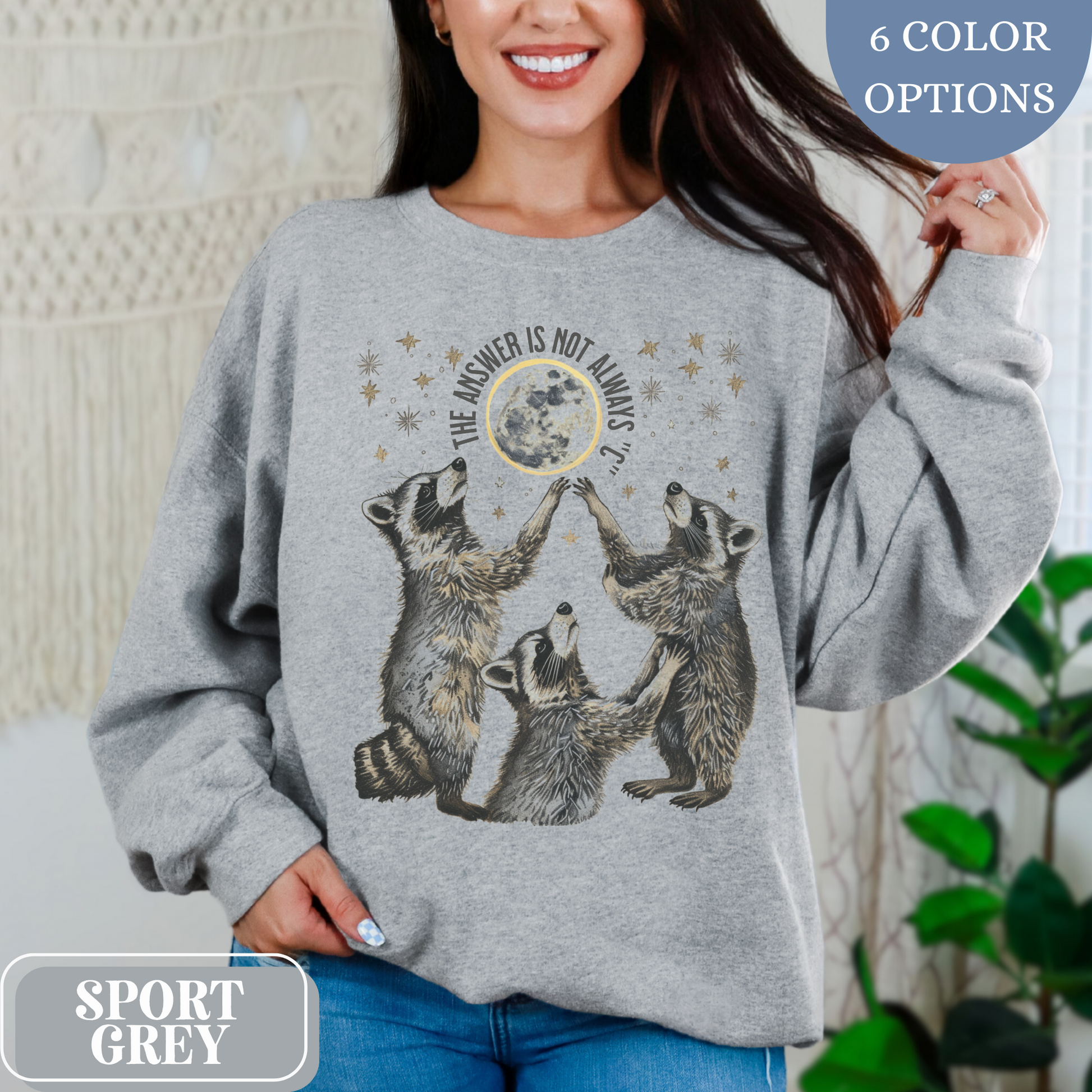 Sport Grey Gildan 18000 Sweatshirt with large raccoon and moon/stars graphic that says "The Answer Is Not Always 'C'" - funny meme crewneck for teachers. Great gift for education grad or major, new teacher, educators, etc. Weird teachers goblincore.