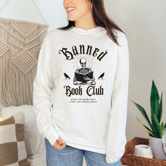 White - Banned Book Club Comfort Colors long-sleeve t-shirt for reading lover. Has a spooky graphic of a skeleton reading and says "Dying for knowledge? Fight for banned books."  Perfect gift for avid readers, literary enthusiasts, English majors and librarians.